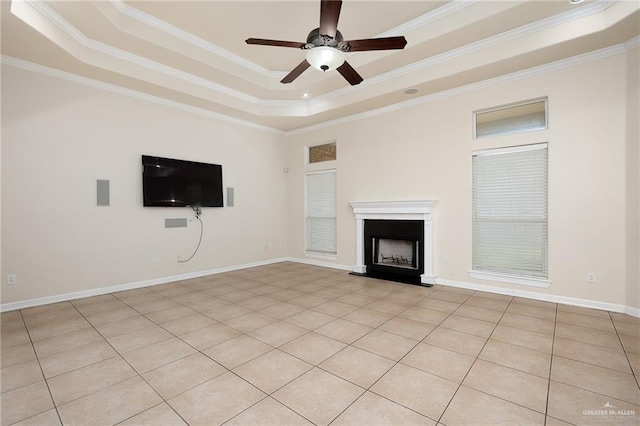 unfurnished living room featuring ceiling fan, ornamental molding, light tile patterned floors, and a tray ceiling