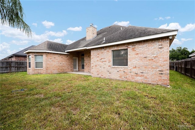 rear view of house featuring a lawn