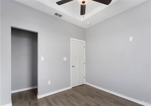 unfurnished bedroom with visible vents, a ceiling fan, baseboards, and wood finished floors