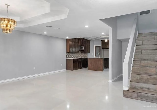 unfurnished living room with visible vents, recessed lighting, stairway, an inviting chandelier, and baseboards