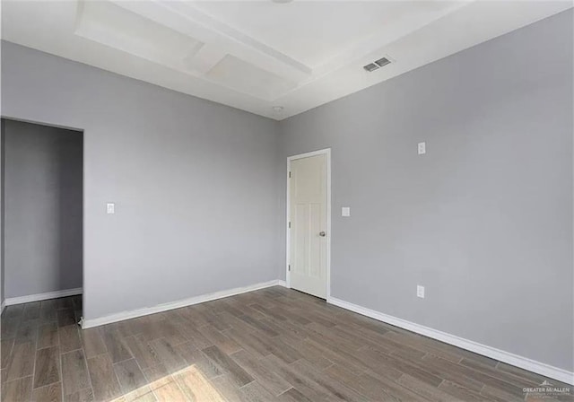 unfurnished room with visible vents, baseboards, beam ceiling, and wood finished floors