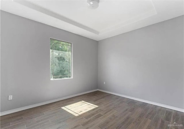 spare room featuring wood finished floors and baseboards