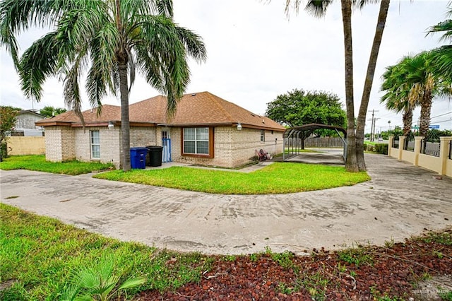 back of property with a carport and a lawn