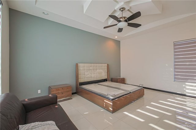 tiled bedroom with a tray ceiling and ceiling fan