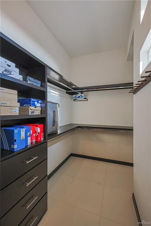 spacious closet with light tile patterned floors