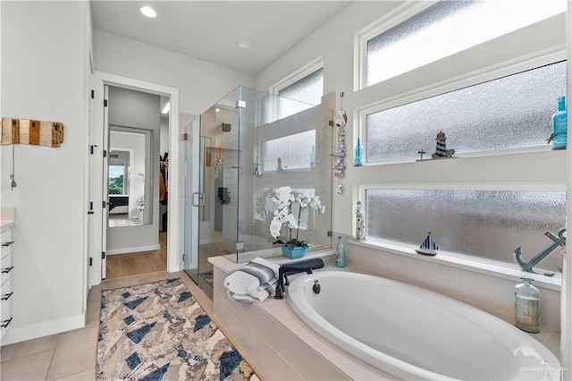 bathroom featuring vanity, plus walk in shower, and tile patterned flooring