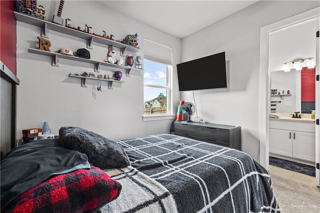 tiled bedroom featuring connected bathroom and sink