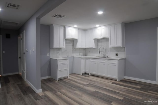 210 E Hurst St E, Harlingen, TX 78550 - kitchen with a sink, dark wood-type flooring, tasteful backsplash, white cabinetry, and baseboards