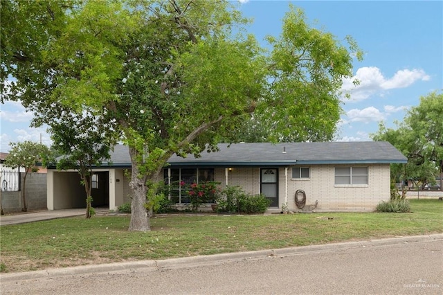 ranch-style home with a front lawn, concrete driveway, an attached carport, and brick siding
