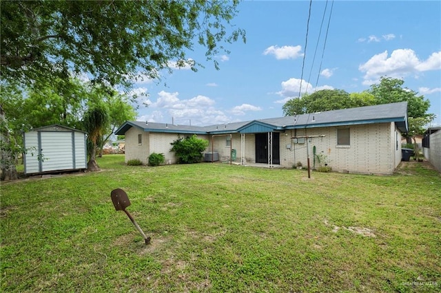 back of property with an outdoor structure, a storage shed, a lawn, and brick siding