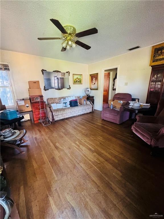 bedroom featuring ceiling fan, wood-type flooring, and a textured ceiling