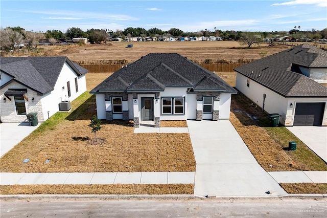 modern farmhouse style home with central AC, roof with shingles, and stucco siding