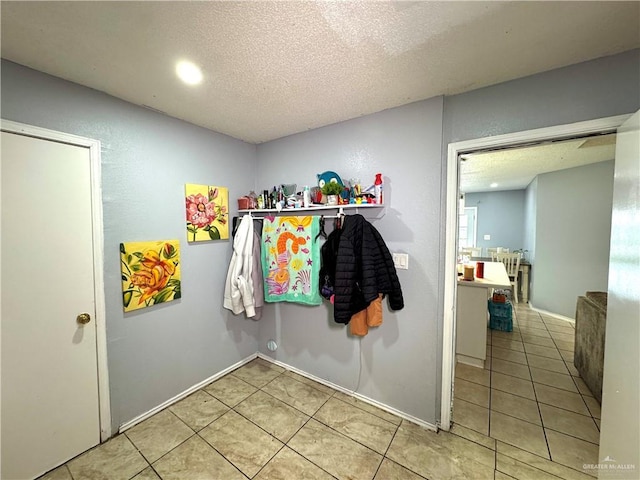 interior space with a textured ceiling and tile patterned floors