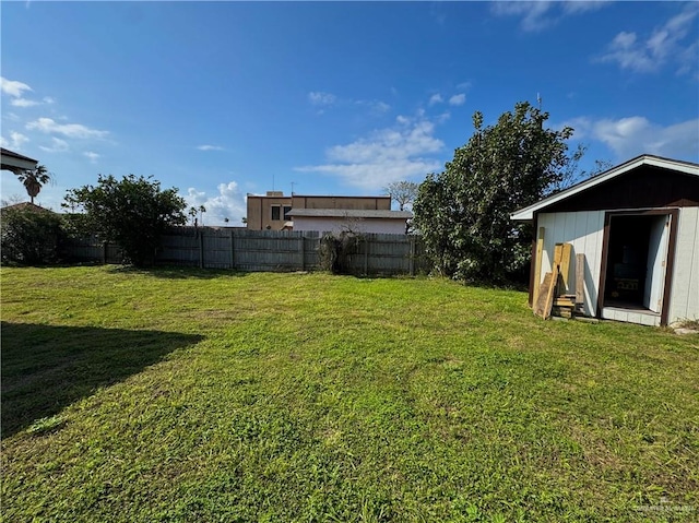 view of yard featuring an outbuilding, a fenced backyard, and a shed