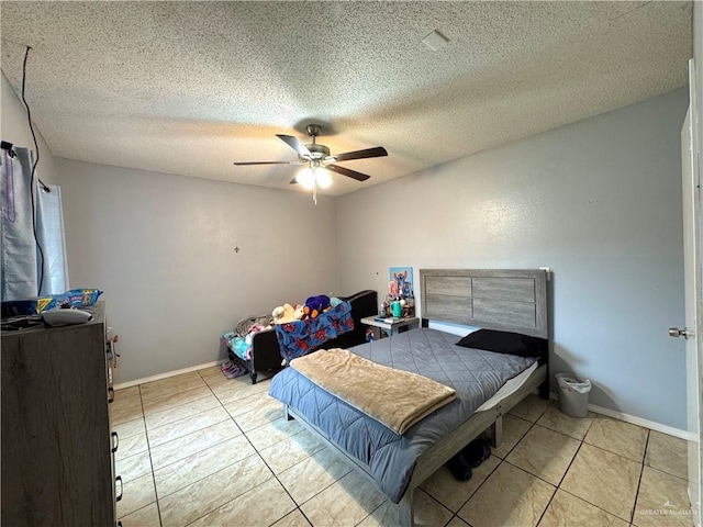 bedroom featuring ceiling fan, a textured ceiling, baseboards, and light tile patterned floors