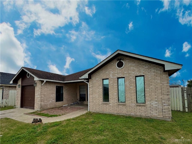 view of front of property featuring brick siding, concrete driveway, an attached garage, fence, and a front lawn