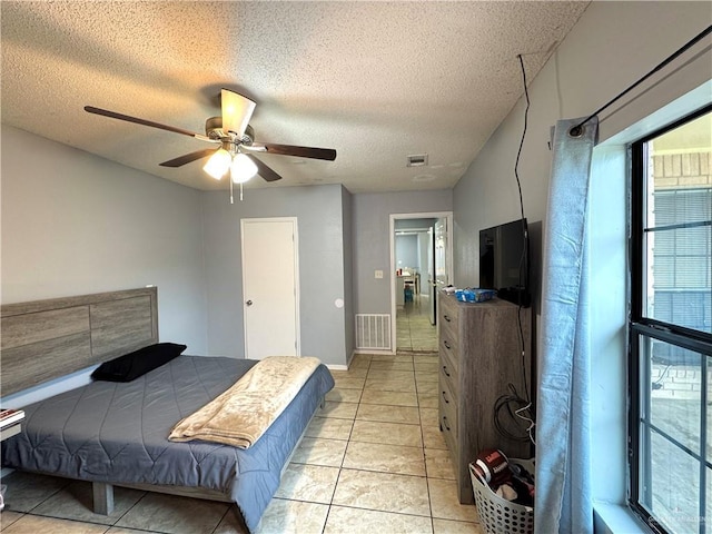 bedroom featuring a textured ceiling, light tile patterned flooring, and visible vents