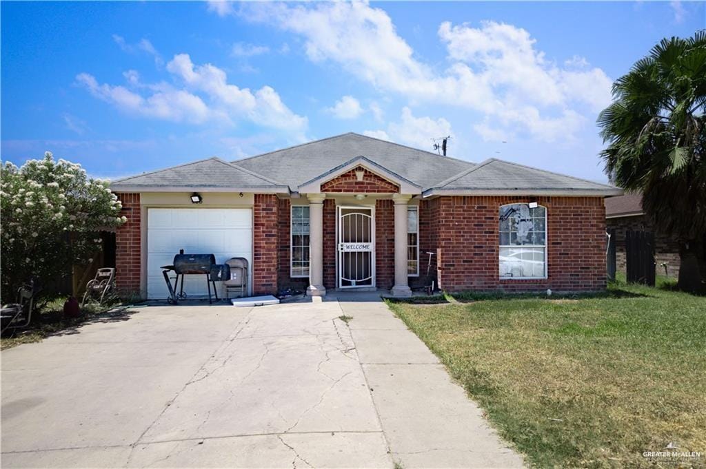 ranch-style house featuring a garage and a front lawn