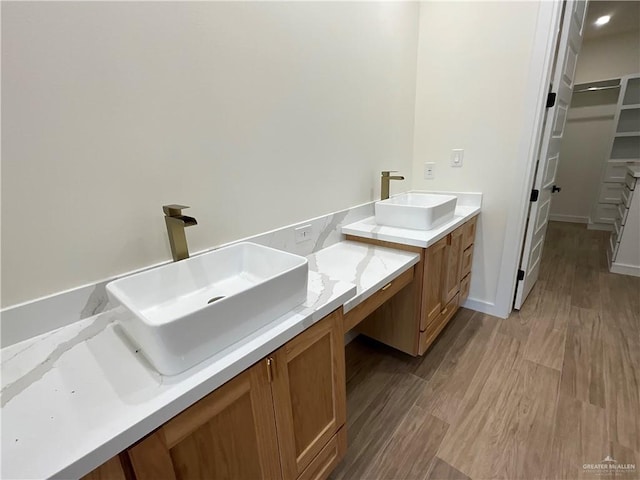1513 Helen Dr, Weslaco, TX 78596 - bathroom featuring vanity, wood finished floors, and a walk in closet