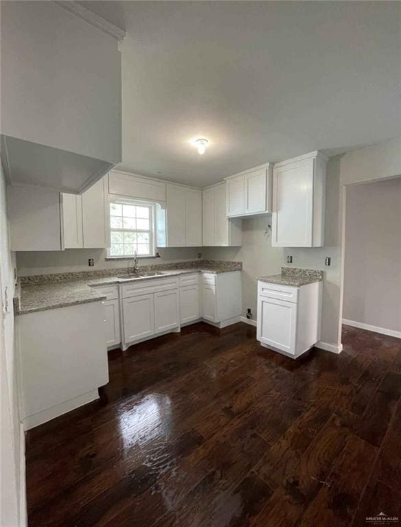 2708 Hackberry St, Weslaco, TX 78596 - kitchen with dark wood-style flooring, white cabinetry, a sink, and baseboards