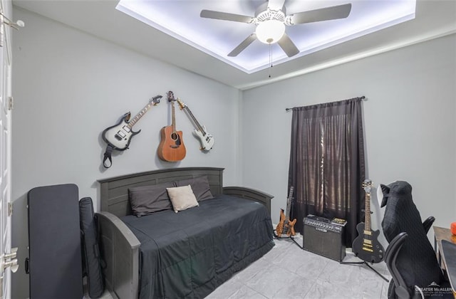 bedroom featuring ceiling fan and a raised ceiling