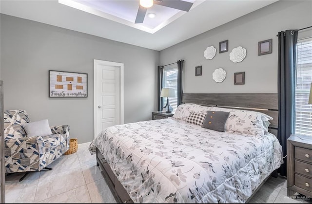 bedroom featuring a raised ceiling and ceiling fan