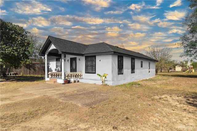 view of front of home with covered porch and a yard