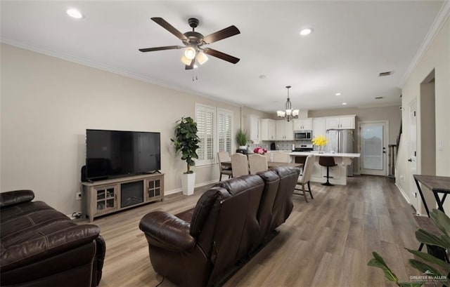 living room featuring crown molding, light hardwood / wood-style flooring, and ceiling fan with notable chandelier