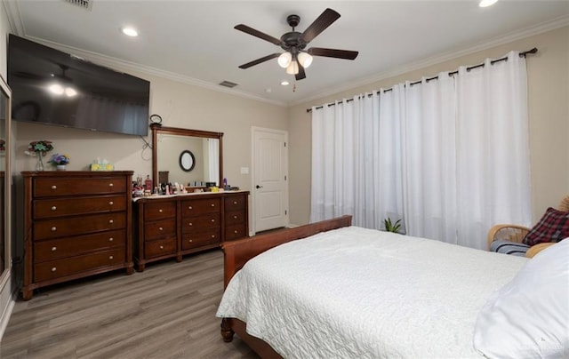 bedroom with ceiling fan, light hardwood / wood-style floors, and ornamental molding