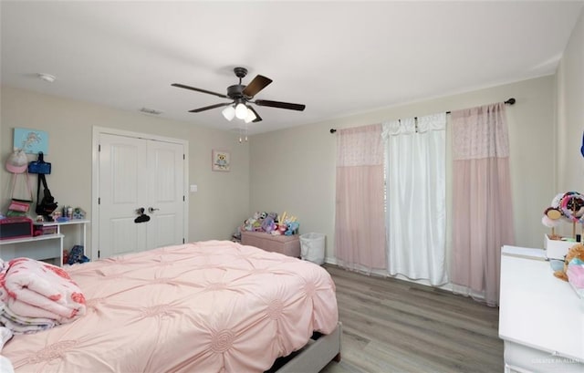 bedroom with a closet, ceiling fan, and light wood-type flooring