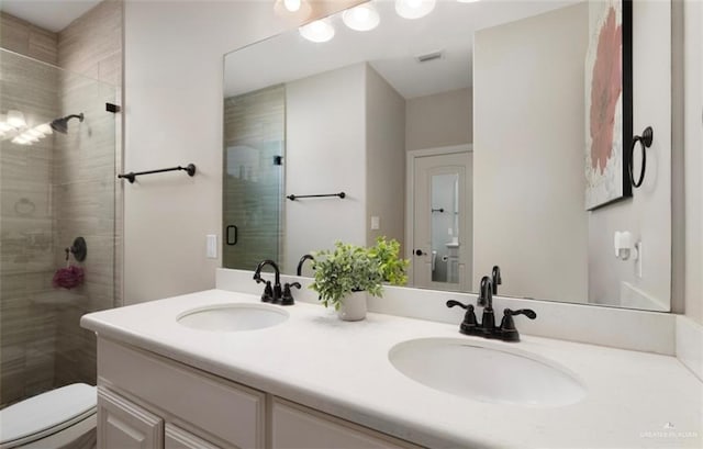 bathroom with toilet, an enclosed shower, and vanity