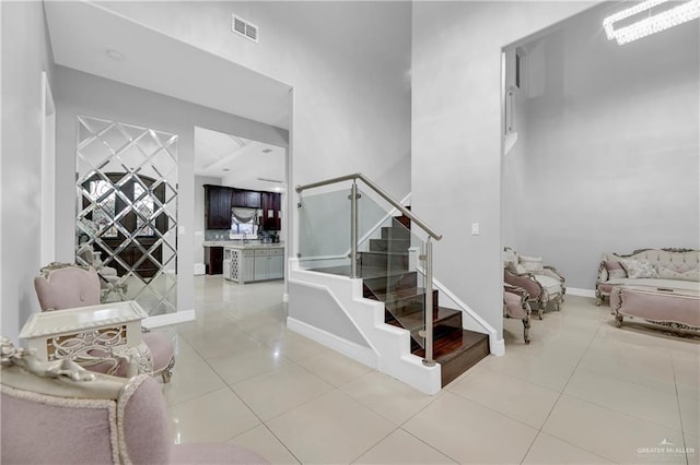 stairway featuring visible vents, baseboards, and tile patterned floors