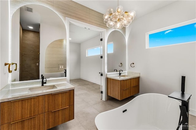 4916 N 26th St, Mcallen, TX 78504 - full bath with two vanities, a soaking tub, a chandelier, and tile patterned flooring