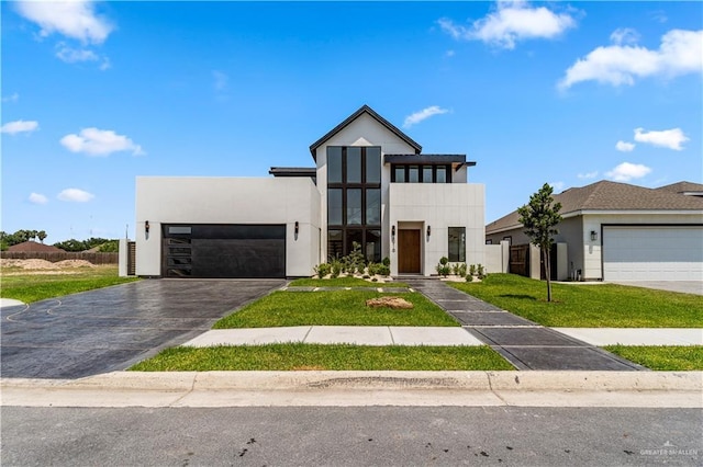 4916 N 26th St, Mcallen, TX 78504 - contemporary home with stucco siding, an attached garage, a front lawn, and driveway