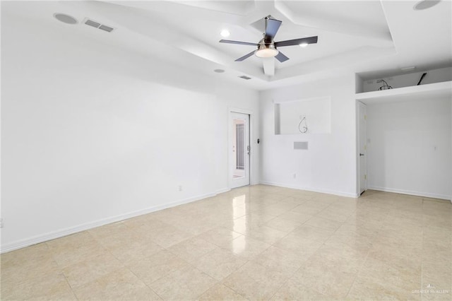 spare room featuring ceiling fan and a tray ceiling