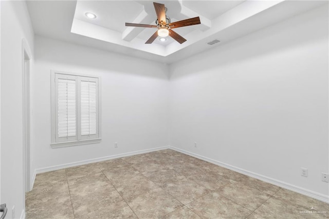 spare room with ceiling fan and a raised ceiling