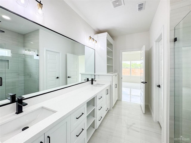 full bath with visible vents, a sink, marble finish floor, and a stall shower
