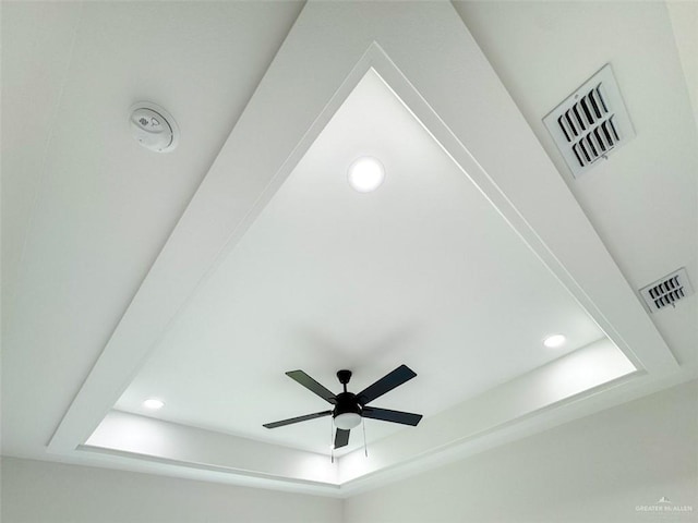 details featuring ceiling fan, a tray ceiling, recessed lighting, and visible vents