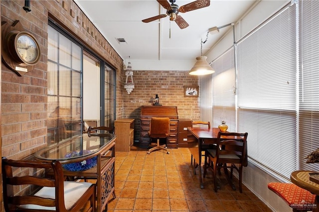 1923 Tyler St, Mission, TX 78572 - dining area with ceiling fan, brick wall, and light tile patterned floors