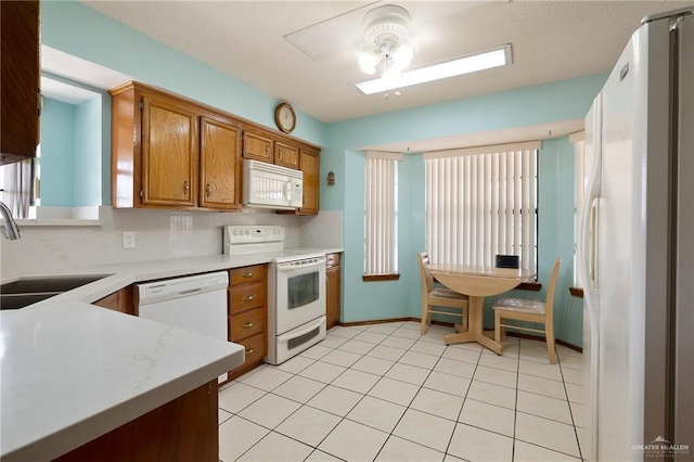 1923 Tyler St, Mission, TX 78572 - kitchen with white appliances, a sink, ceiling fan, light countertops, and brown cabinets