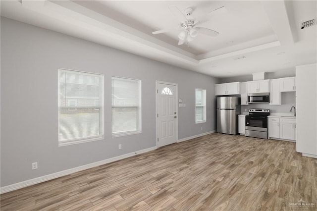 kitchen with visible vents, white cabinets, appliances with stainless steel finishes, light wood finished floors, and a raised ceiling