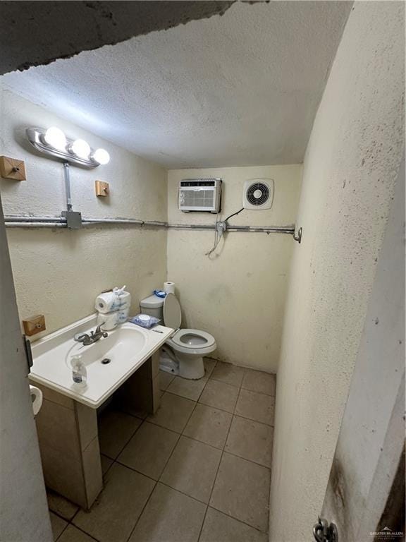 bathroom with vanity, a textured ceiling, a wall mounted AC, tile patterned flooring, and toilet