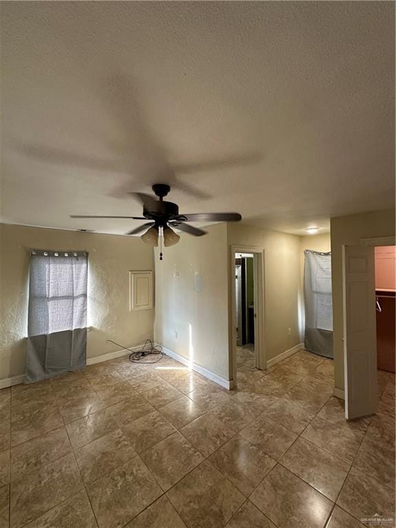 empty room featuring a textured ceiling and ceiling fan