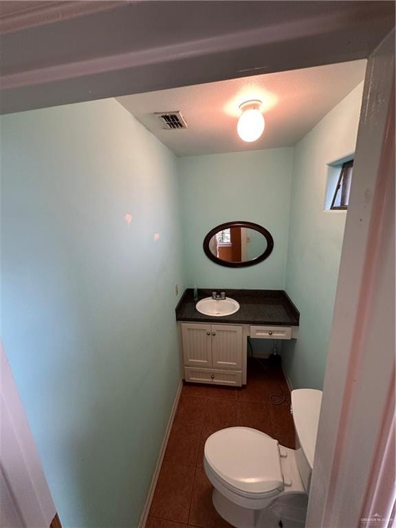 bathroom with tile patterned flooring, vanity, and toilet