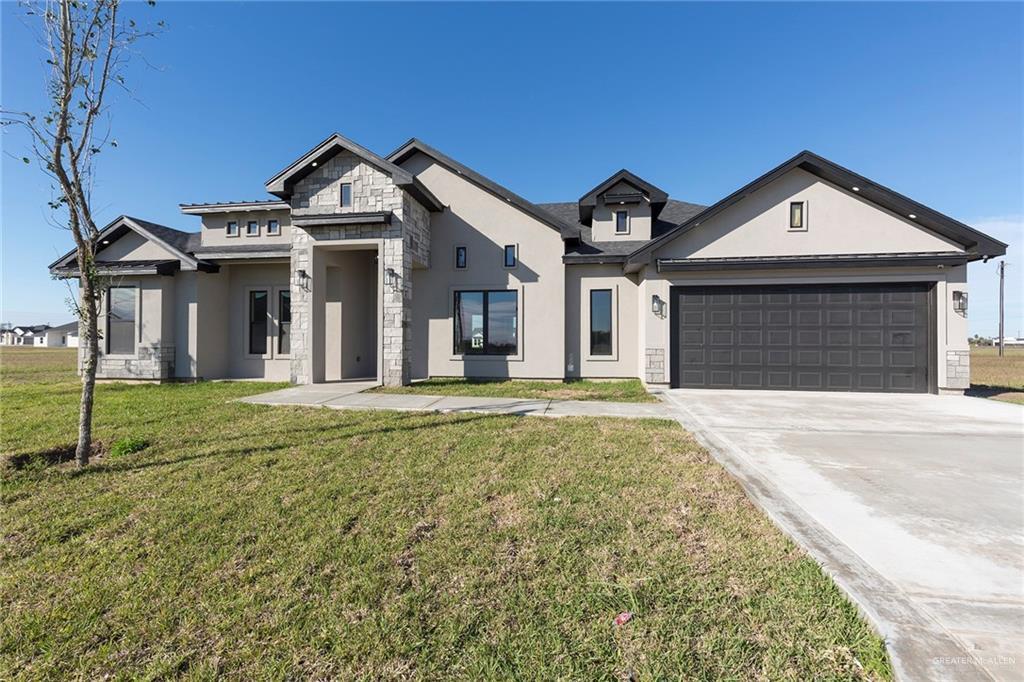 view of front of home with a front yard and a garage