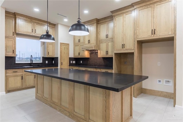 kitchen featuring sink, light brown cabinets, a center island, and hanging light fixtures