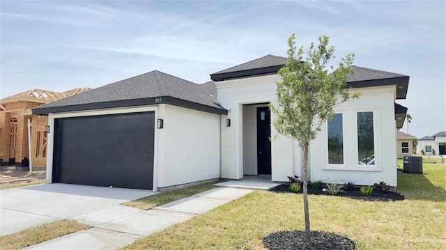 view of front of home with cooling unit, stucco siding, a front lawn, concrete driveway, and a garage