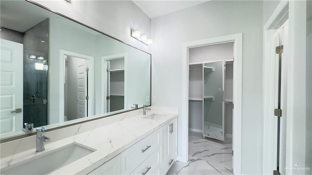 full bathroom featuring a sink, a walk in closet, and marble finish floor