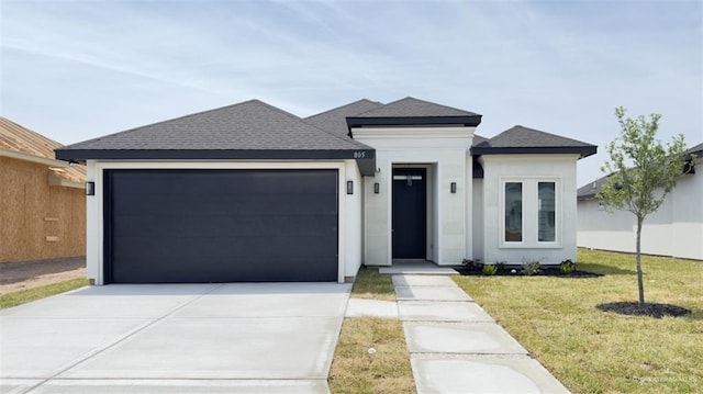 view of front of home with driveway, an attached garage, a front lawn, and roof with shingles