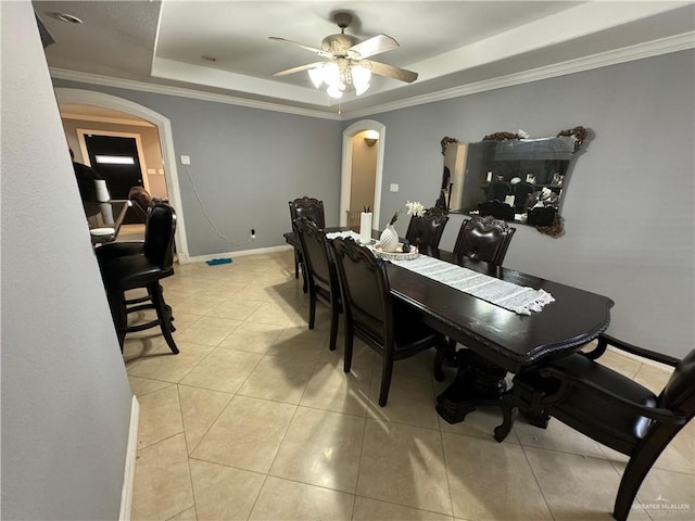 dining space with a tray ceiling, ceiling fan, and crown molding